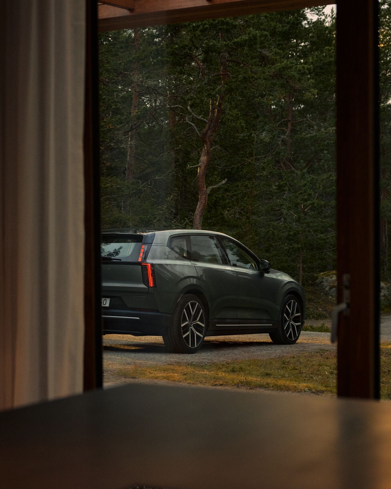 Volvo EX60 bij huis in bosrijke omgeving